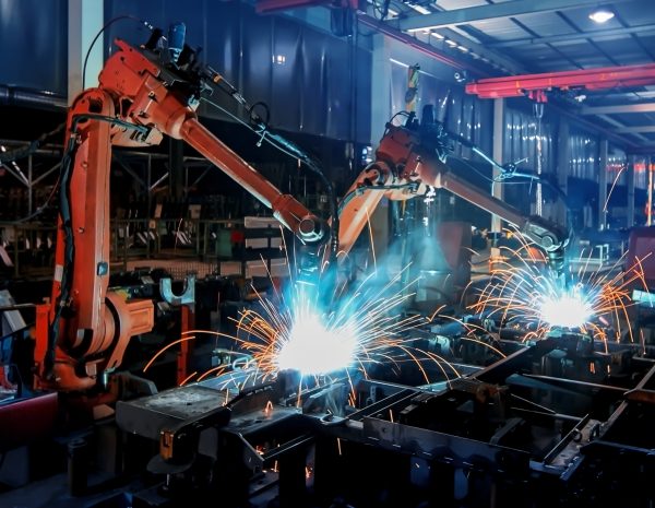 Large factory robotic arms are spraying sparks to weld car frames Large factory robotic arms are spraying sparks to weld car frames